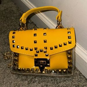 Yellow gold colored purse with gold detailing all around.